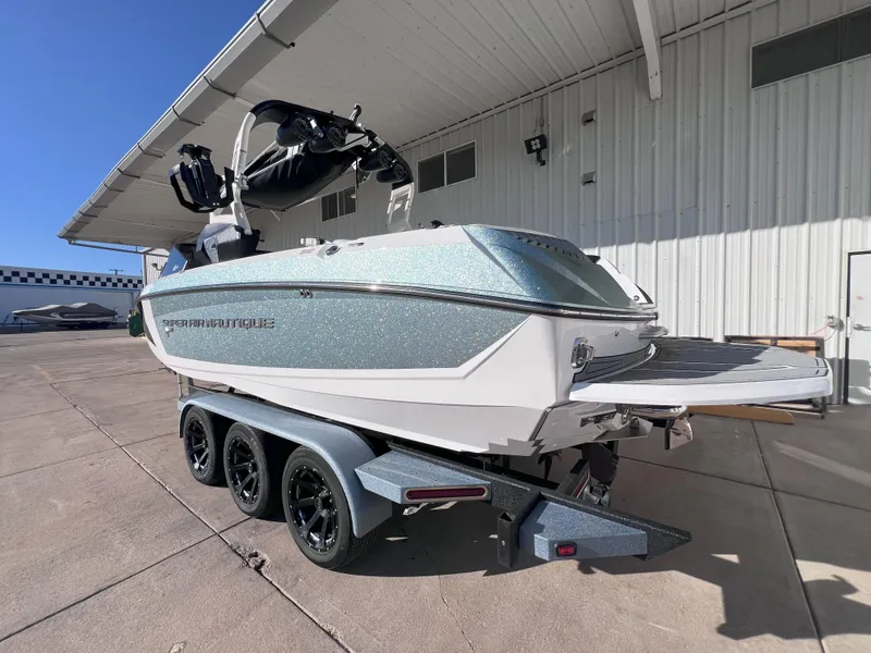 Slide: The Image of 2019 Nautique Super Air Nautique G25 boat on a trailer outside a warehouse. - 9
