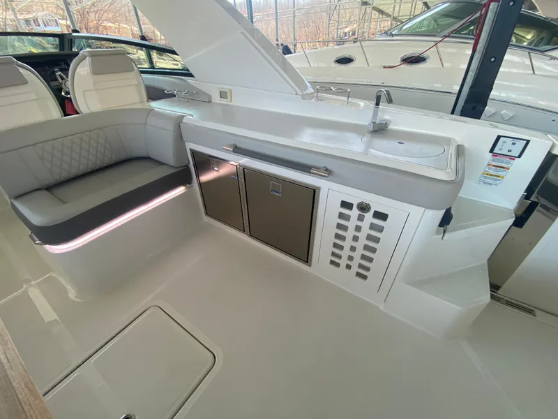 Slide: The Image of 2023 Sea Ray SLX 400 OB interior with seating, sink, and storage cabinets. - 17