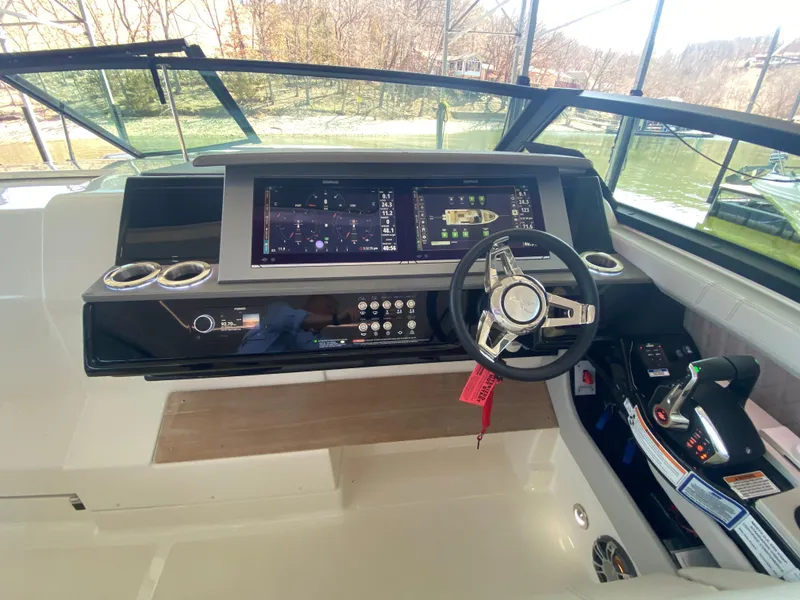 Slide: The Image of 2023 Sea Ray SLX 400 OB helm with advanced navigation system and sleek steering wheel. - 24