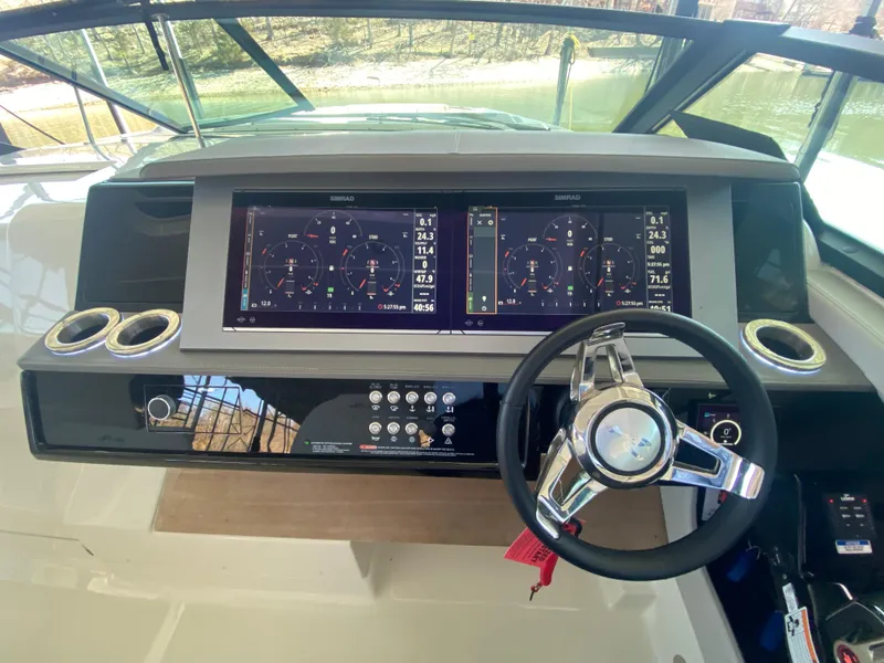 Slide: The Image of 2023 Sea Ray SLX 400 OB helm with dual displays and modern steering wheel. - 25