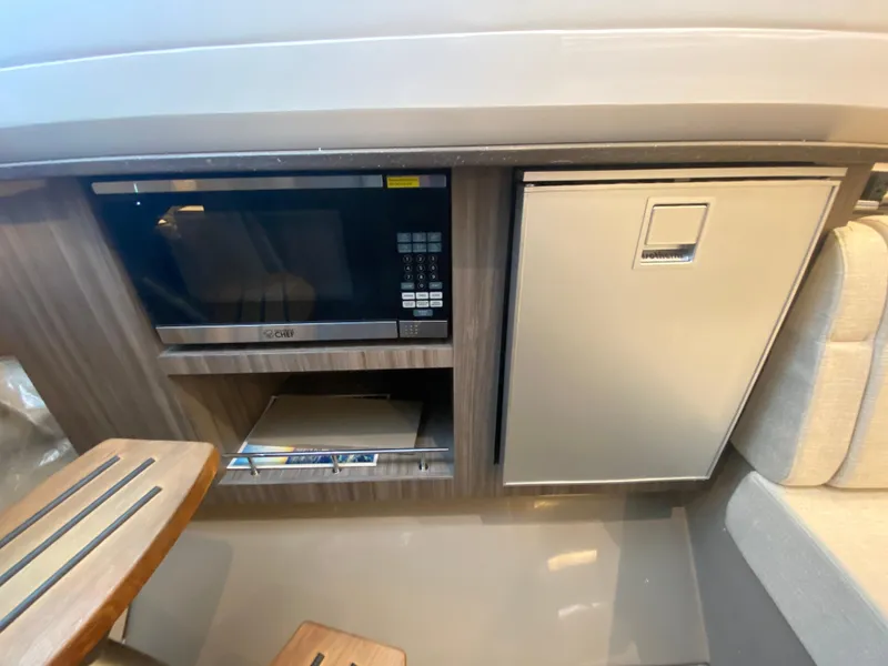 Slide: The Image of 2023 Sea Ray SLX 400 OB interior with microwave and compact fridge. - 43