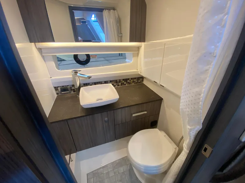 Slide: The Image of 2023 Sea Ray SLX 400 OB bathroom with modern sink, toilet, and sleek cabinetry. - 45