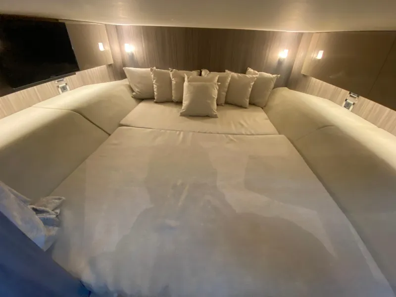 Slide: The Image of Luxurious interior cabin of 2023 Sea Ray SLX 400 OB with plush bedding and ambient lighting. - 48