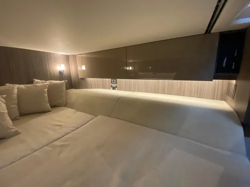 Slide: The Image of 2023 Sea Ray SLX 400 OB cabin interior with modern design and cozy bedding. - 50