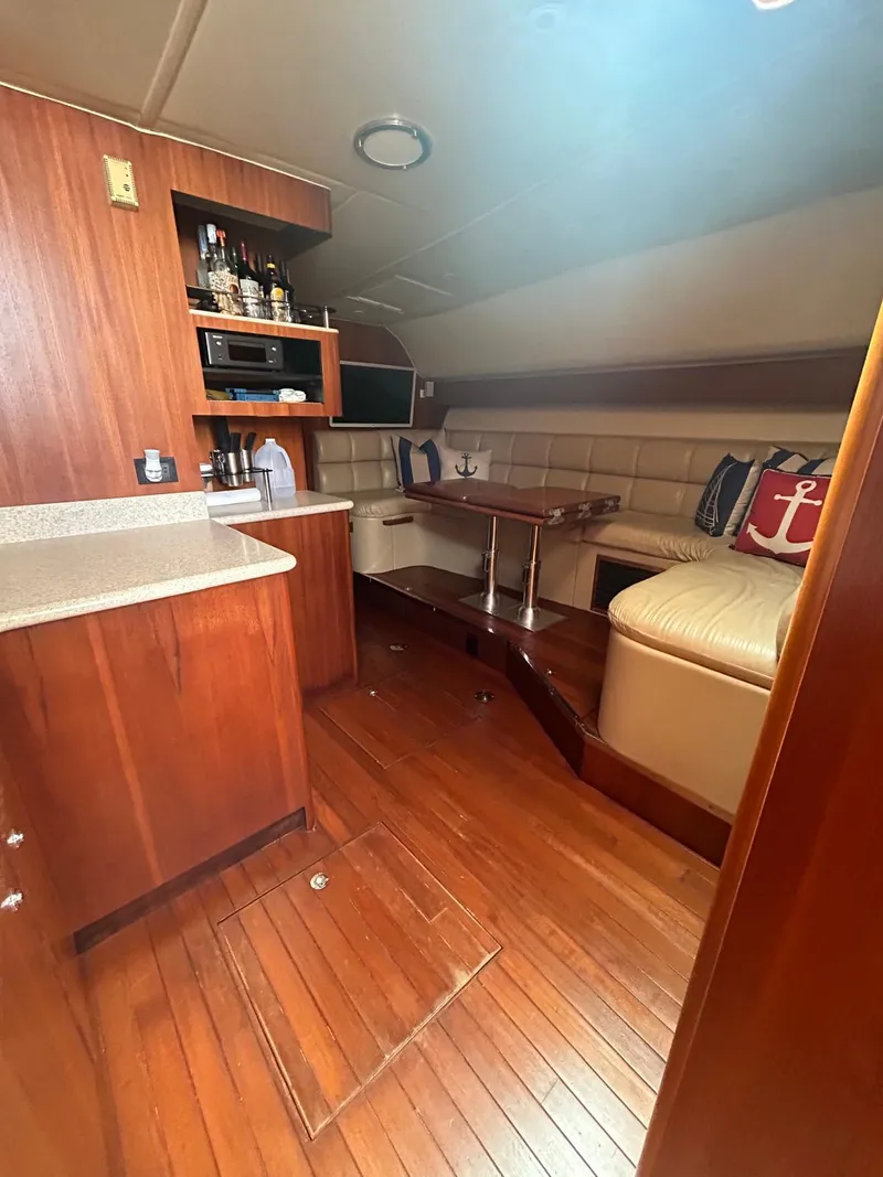 Slide: The Image of 2003 Tiara Yachts 4000 Express interior with wood flooring, kitchenette, and seating area. - 10