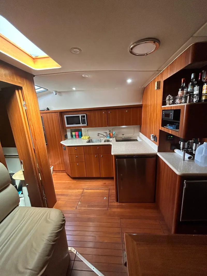 Slide: The Image of Interior of 2003 Tiara Yachts 4000 Express with wooden cabinetry and modern kitchen amenities. - 16