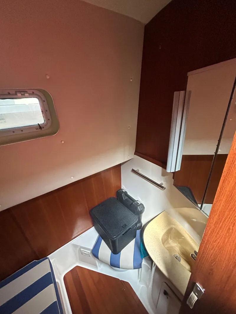 Slide: The Image of 2003 Tiara Yachts 4000 Express bathroom with wood paneling and compact sink. - 8