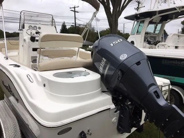 Slide: The Image of 2018 NauticStar 2102 Legacy boat with Yamaha 150 engine, beige seating, and control panel. - 1