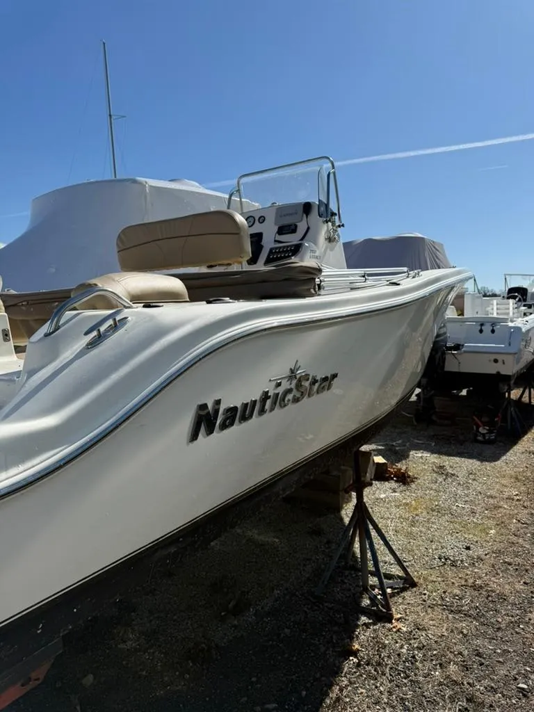 Slide: The Image of 2018 NauticStar 2102 Legacy boat on display under clear blue sky. - 11