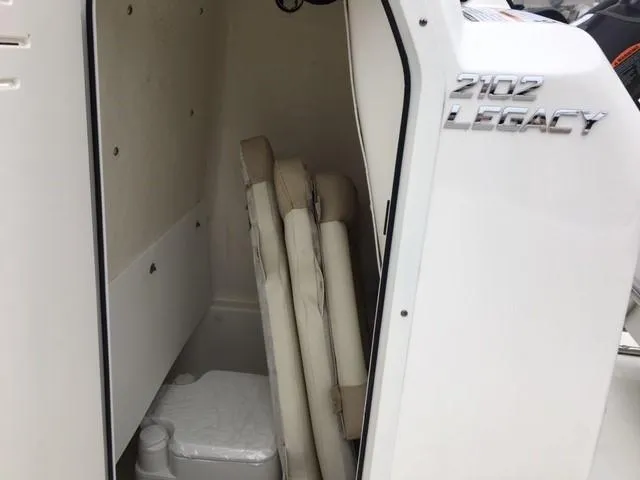 Slide: The Image of 2018 NauticStar 2102 Legacy boat interior with storage and seating area. - 2