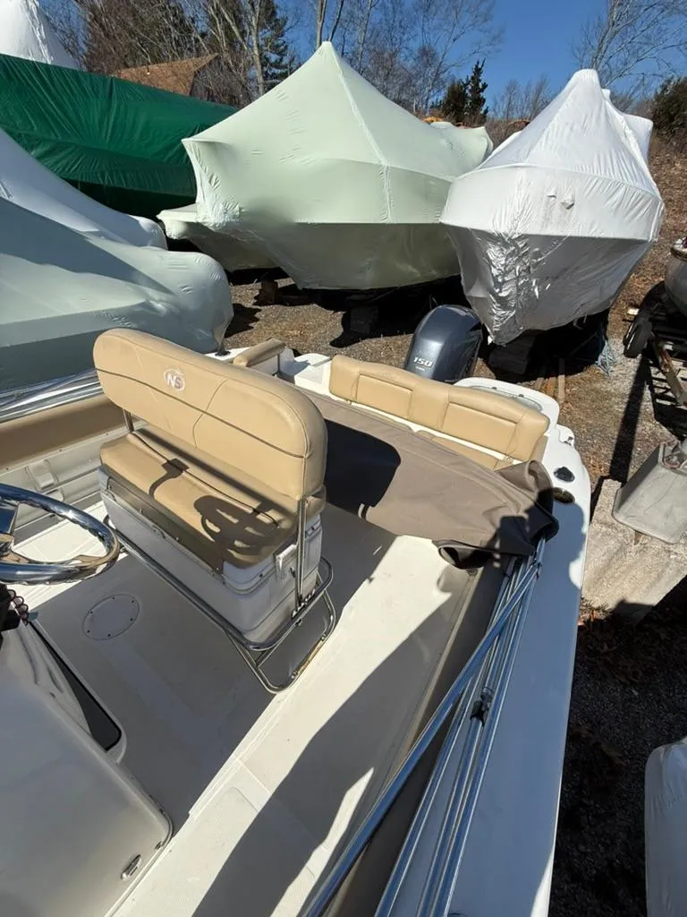 Slide: The Image of 2018 NauticStar 2102 Legacy boat with covered seating, parked outdoors. - 9