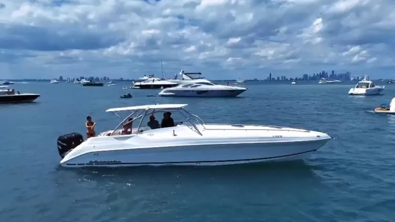 Slide: The Image of 2018 Intermarine 380 Sport boat cruising on a sunny day with city skyline in background. - 13