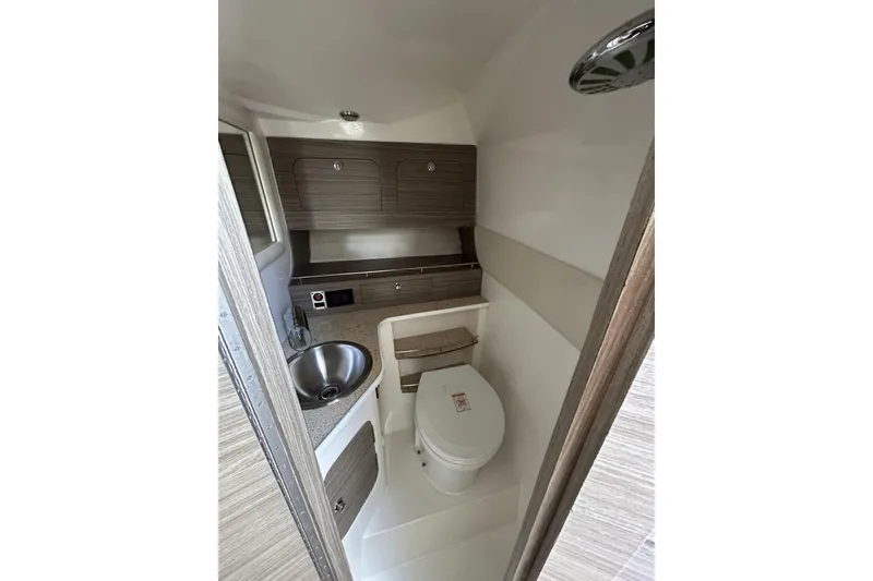 Slide: The Image of 2018 Intermarine 380 Sport boat bathroom with sink, toilet, and wooden cabinetry. - 29