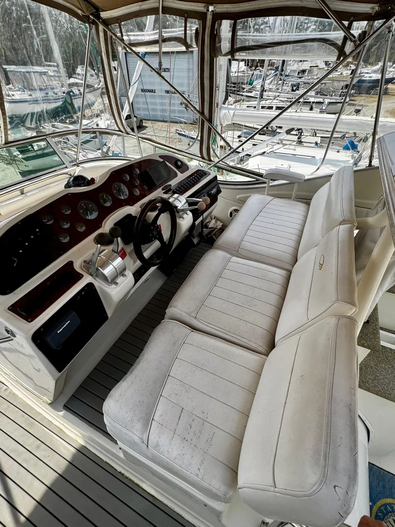 Slide: The Image of 1998 Maxum 4100 SCA yacht cockpit with white seating and control panel. - 36