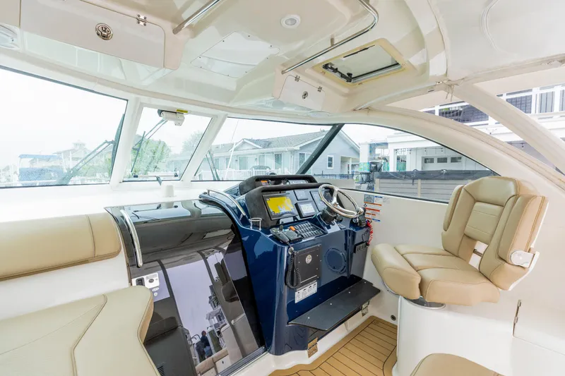 Slide: The Image of 2018 Pursuit OS 385 Offshore helm with modern controls and beige seating. - 14