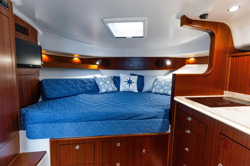 Slide: The Image of Luxurious cabin interior of 2018 Pursuit OS 385 Offshore with cozy bed and elegant wood finish. - 16