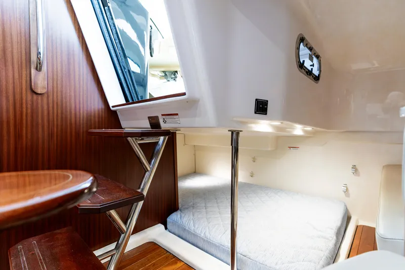 Slide: The Image of 2018 Pursuit OS 385 Offshore cabin interior with wooden steps and cozy sleeping area. - 24