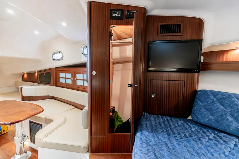 Slide: The Image of Luxurious interior of 2018 Pursuit OS 385 Offshore boat with seating, TV, and wood finishes. - 34
