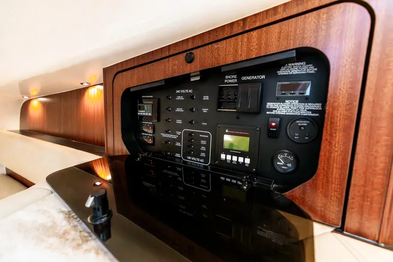 Slide: The Image of 2018 Pursuit OS 385 Offshore electrical panel with wood finish and ambient lighting. - 36