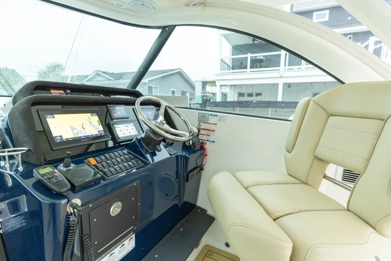 Slide: The Image of 2018 Pursuit OS 385 Offshore helm with navigation screens and beige seating. - 38