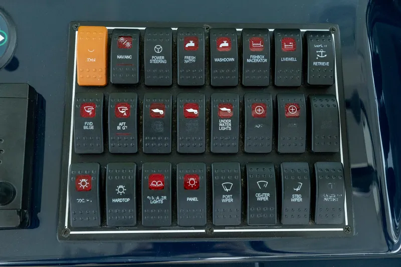 Slide: The Image of Control panel of a 2018 Pursuit OS 385 Offshore boat with labeled switches. - 42