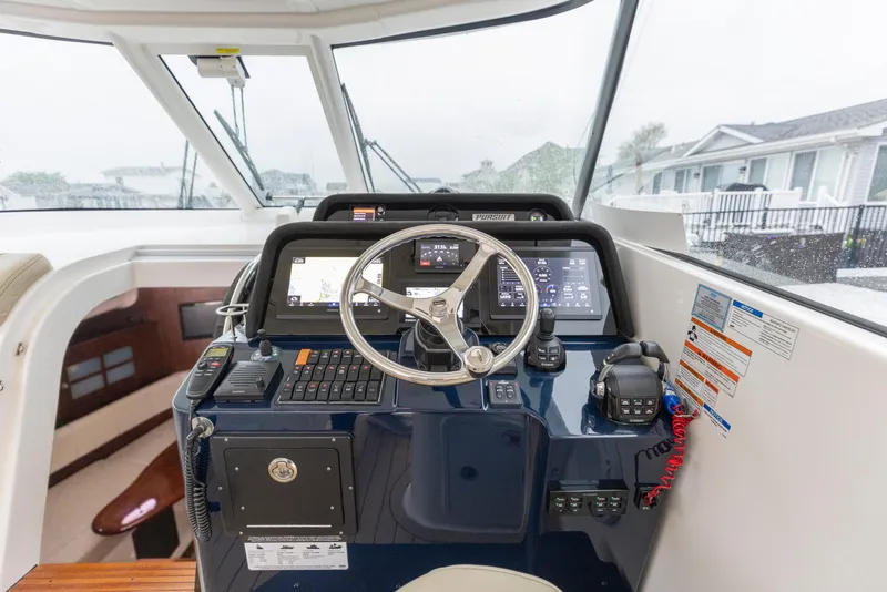 Slide: The Image of 2018 Pursuit OS 385 Offshore helm with navigation controls and steering wheel. - 43