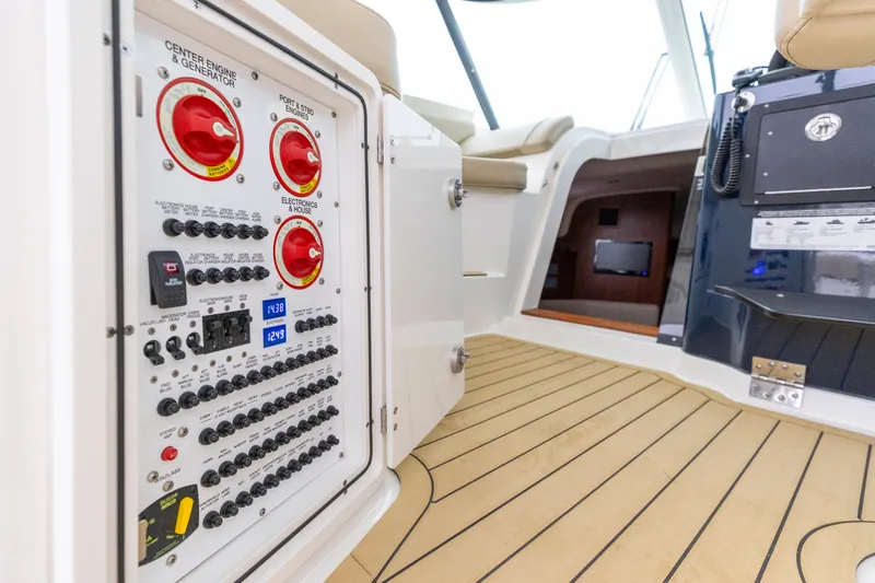 Slide: The Image of 2018 Pursuit OS 385 Offshore boat interior with control panel and teak flooring. - 47