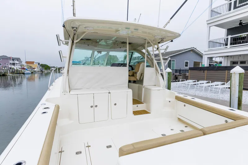 Slide: The Image of 2018 Pursuit OS 385 Offshore boat docked near waterfront homes. - 5