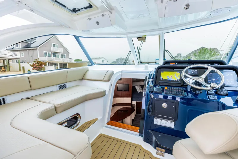 Slide: The Image of 2018 Pursuit OS 385 Offshore boat interior with helm, seating, and navigation equipment. - 8