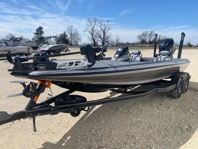 Slide: The Image of 2025 Skeeter ZXR21 boat on trailer, parked outdoors under clear blue sky. - 2