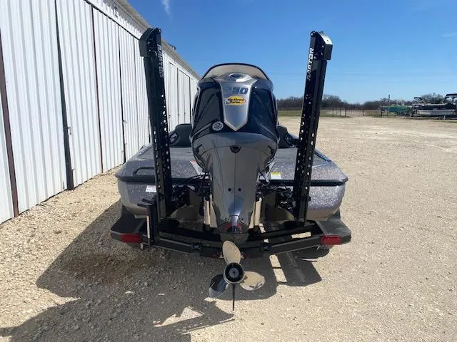Slide: The Image of 2025 Skeeter ZXR21 boat with powerful outboard motor, parked on gravel near a building. - 4