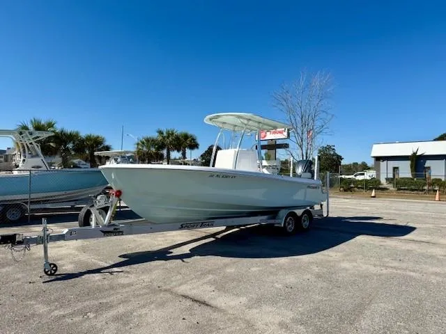 Slide: The Image of 2024 Contender 24 Sport boat on trailer, parked outdoors under clear blue sky. - 0