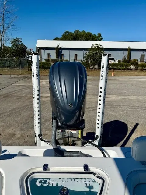 Slide: The Image of 2024 Contender 24 Sport boat with powerful outboard motor, parked outdoors. - 13
