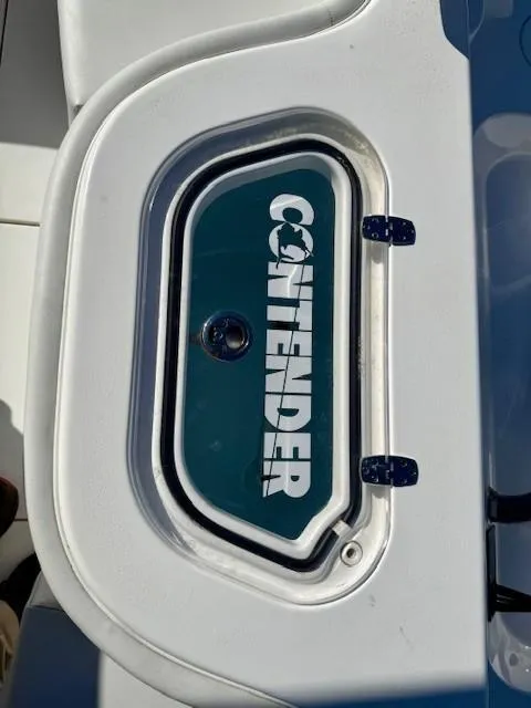 Slide: The Image of 2024 Contender 24 Sport boat compartment with logo on white surface. - 16