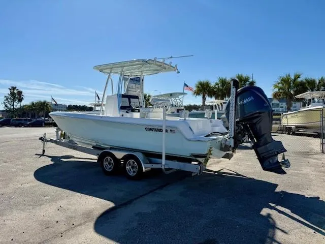 Slide: The Image of 2024 Contender 24 Sport boat on trailer, parked outdoors under clear sky. - 4