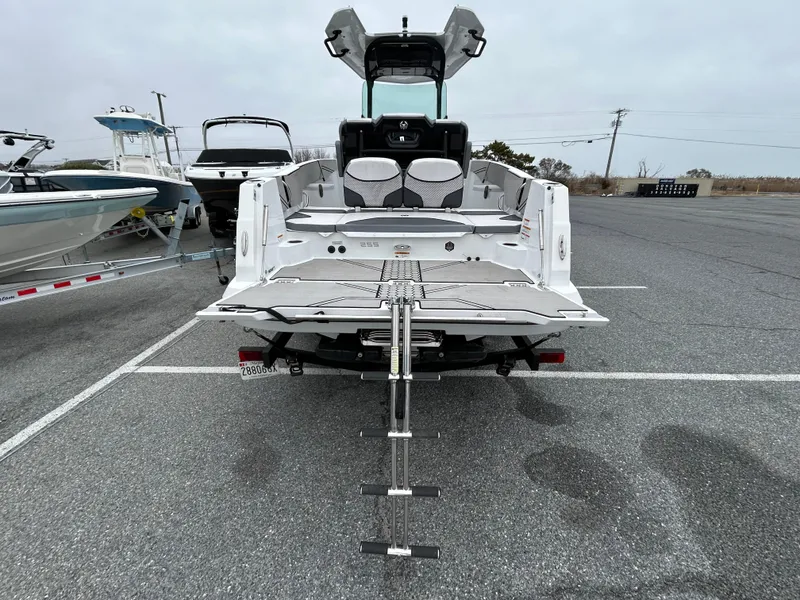 Slide: The Image of 2020 Scarab 255 Open ID boat with swim platform and ladder, parked in a marina. - 12