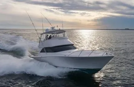 Slide: The Image of 2006 Viking 48 yacht cruising on open water at sunset. - 1