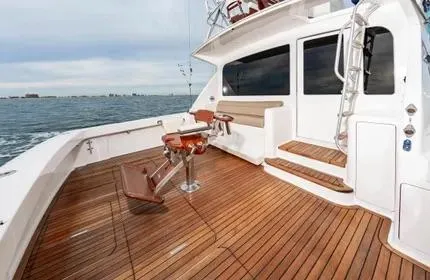 Slide: The Image of Luxury 2006 Viking 48 yacht with teak deck and fishing chair on open sea. - 12