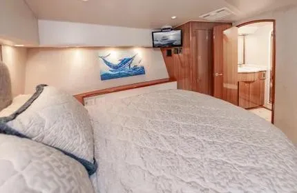 Slide: The Image of Luxurious cabin interior of 2006 Viking 48 yacht with cozy bedding and modern amenities. - 24