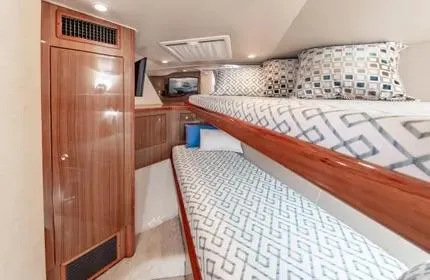 Slide: The Image of 2006 Viking 48 yacht interior with wooden cabinetry and twin bunk beds. - 27