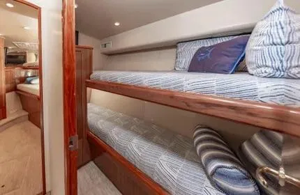 Slide: The Image of 2006 Viking 48 yacht interior with cozy bunk beds and striped pillows. - 28
