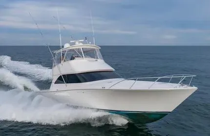 Slide: The Image of 2006 Viking 48 yacht cruising on open water under a clear sky. - 45