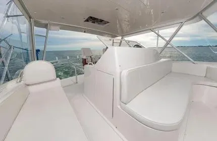 Slide: The Image of 2006 Viking 48 yacht interior with white seating, ocean view, and spacious layout. - 8
