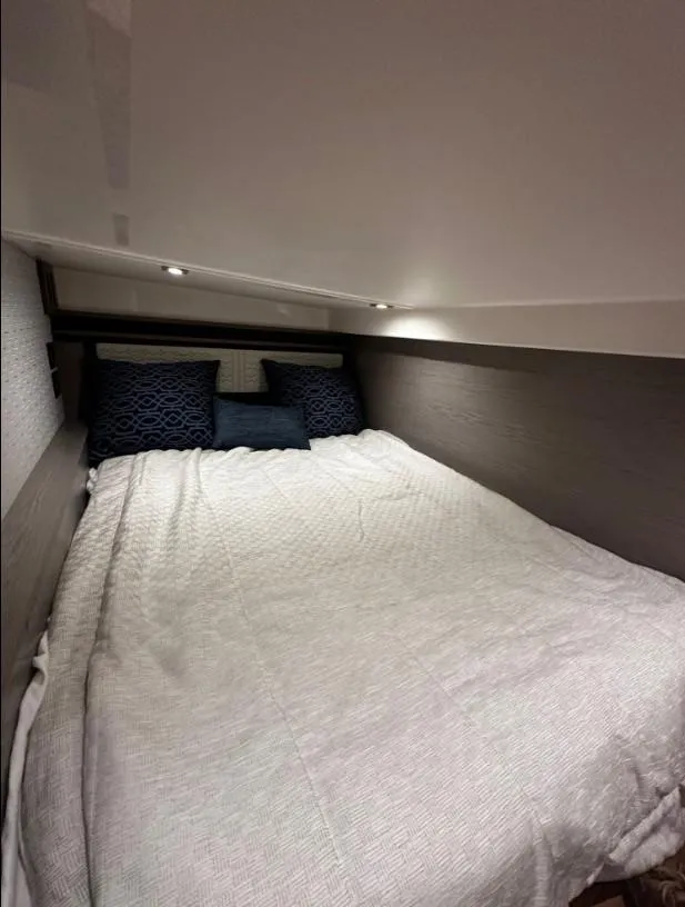 Slide: The Image of Interior cabin of 2023 Tiara Yachts 43 LE with cozy bedding and ambient lighting. - 10