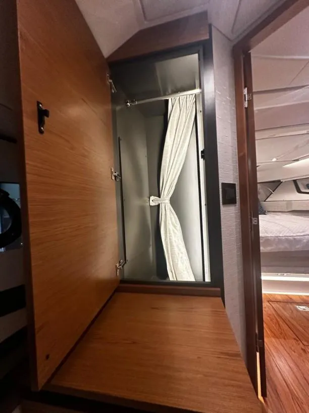 Slide: The Image of Interior cabin of 2023 Tiara Yachts 43 LE, featuring wooden cabinetry and a curtained window. - 13