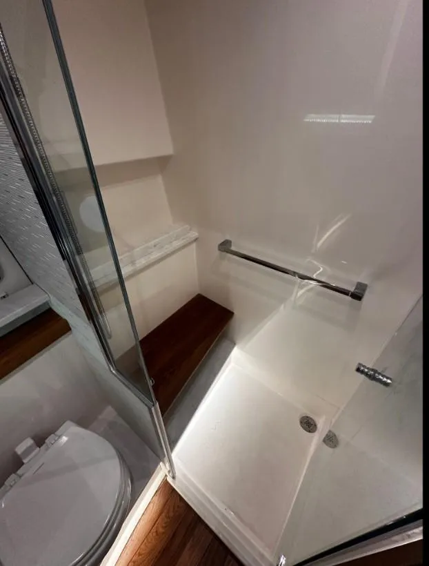 Slide: The Image of 2023 Tiara Yachts 43 LE bathroom with modern shower and wooden accents. - 15