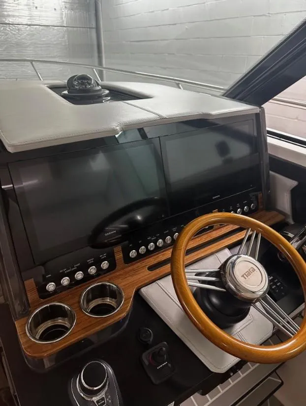 Slide: The Image of 2023 Tiara Yachts 43 LE helm with dual screens and wooden steering wheel. - 17