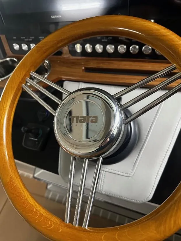 Slide: The Image of Steering wheel of 2023 Tiara Yachts 43 LE, featuring wood and chrome accents. - 19