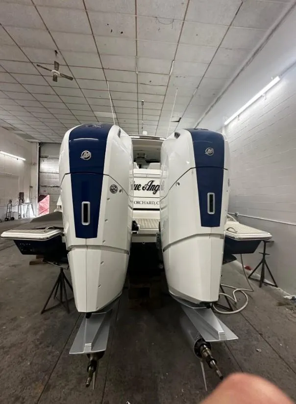Slide: The Image of 2023 Tiara Yachts 43 LE with dual outboard engines in a workshop setting. - 2