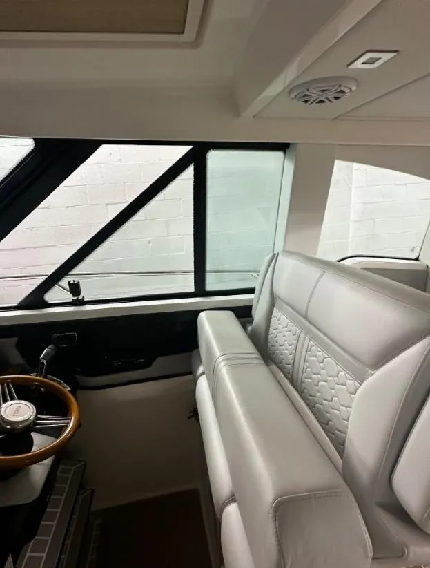 Slide: The Image of 2023 Tiara Yachts 43 LE interior with luxurious seating and steering wheel. - 21